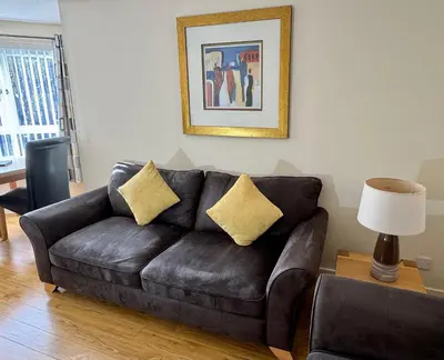 a black leather couch in a living room at Castle Gait, Paisley in Paisley