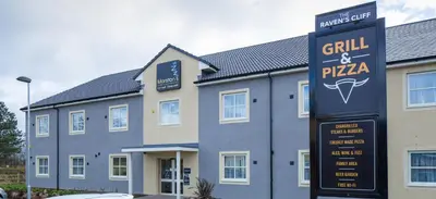 a building with a sign for a grill and pizza at The Raven’s Cliff Lodge by Marston's Inns in Motherwell