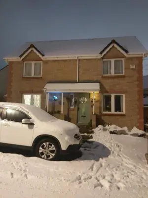 a car parked in front of a house covered in snow at Homely Haven, Dunfermline in Dunfermline