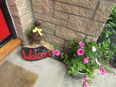 a welcome sign in front of a house with flowers at Homely Haven, Dunfermline in Dunfermline