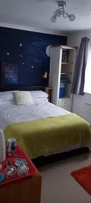 a bedroom with a bed with a yellow blanket at Homely Haven, Dunfermline in Dunfermline