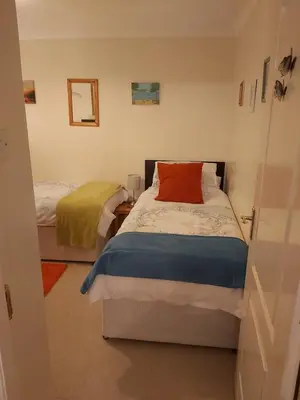 a bedroom with two beds and a red pillow at Homely Haven, Dunfermline in Dunfermline