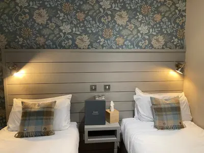 a hotel room with two beds and a wall at West Port Hotel in Linlithgow