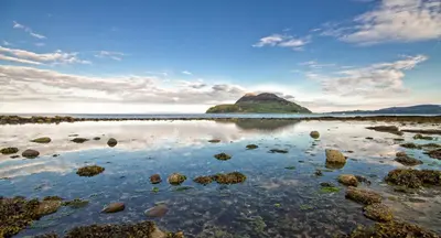 a small island in the ocean with rocks in the water at Lamlash Bay Hotel in Lamlash