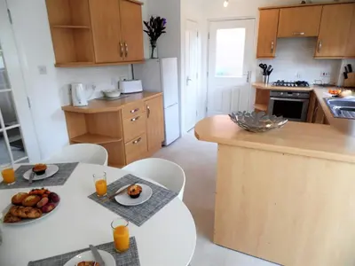a kitchen with a table with a plate of food on it at Signature - Brambling House in Coatbridge