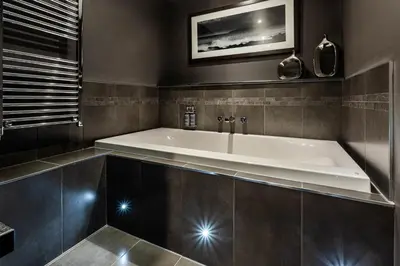 a large bath tub in a bathroom with a sink at Auchrannie Resort in Brodick