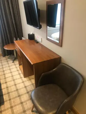 a desk in a room with a chair and a mirror at The Scot in Oban