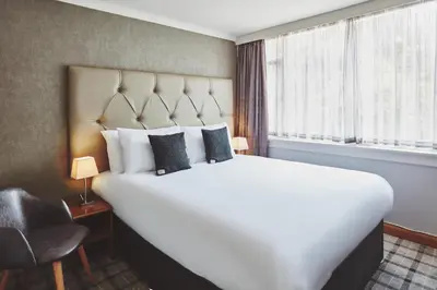 a large white bed in a room with a window at The Scot in Oban