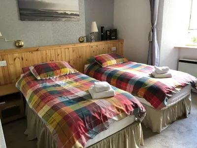 two beds sitting next to each other in a room at Port Askaig Hotel in Port Askaig