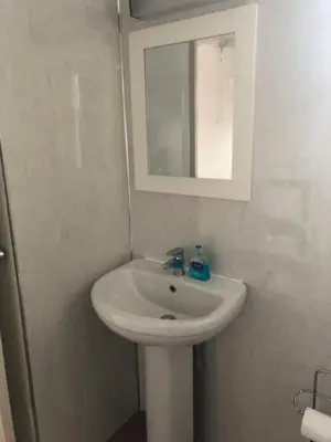 a bathroom with a white sink and a mirror at Port Askaig Hotel in Port Askaig
