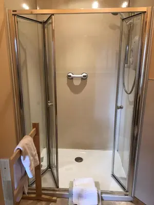 a shower with a glass door in a bathroom at Port Askaig Hotel in Port Askaig