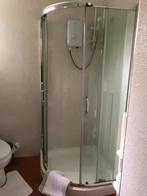 a shower stall in a bathroom with a toilet at Port Askaig Hotel in Port Askaig