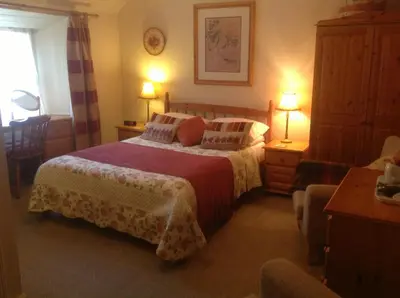 a bedroom with two beds and two tables and two lamps at Comelybank Guesthouse in Crieff