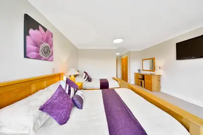 a bedroom with two beds and a flat screen tv at Peggyslea Farm B&B in Edinburgh