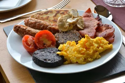 a plate of breakfast food with eggs sausage and tomatoes at Peggyslea Farm B&B in Edinburgh