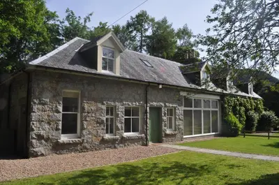 an old stone house with a yard at The Old Coach House, Alltshellach Cottages in North Ballachulish