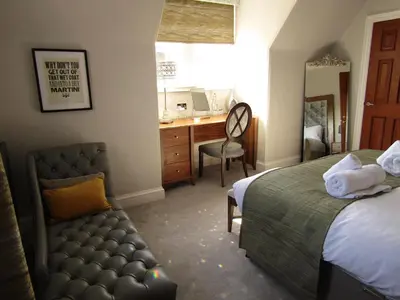 a bedroom with a bed and a desk with a chair at The Craigie Hotel in Penicuik