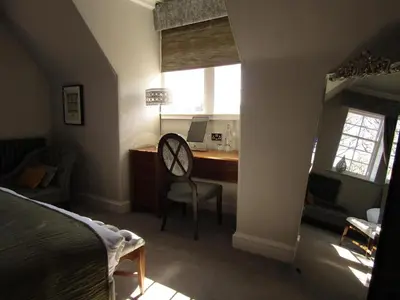 a bedroom with a desk with a computer and a chair at The Craigie Hotel in Penicuik