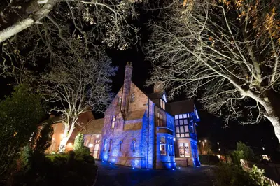 an old church lit up in blue at night at The Craigie Hotel in Penicuik