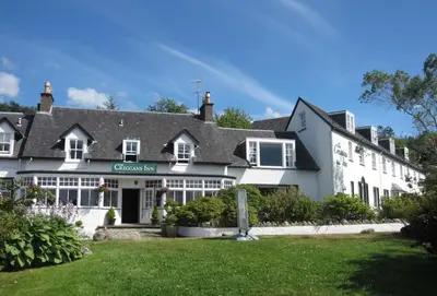 a large white house with a green lawn at Glenbranter Cottage in Strachur