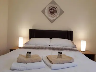 a bedroom with a bed with two towels on it at Crystal Apartments in Airdrie