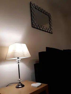 a lamp sitting on a table next to a mirror at Crystal Apartments in Airdrie