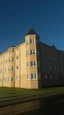 a large brick building on the side of a street at Crystal Apartments in Airdrie