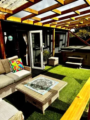 a patio with a couch and a table in the grass at Bumble’s Barn in Slamannan