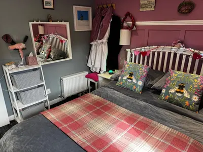 a bedroom with a bed and a mirror at Bumble’s Barn in Slamannan