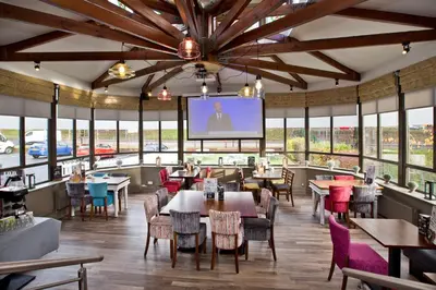 a restaurant with tables and chairs and a projection screen at The Abbey Inn in Paisley