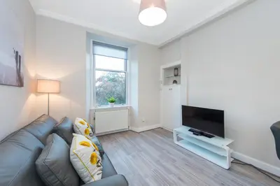 a living room with a couch and a flat screen tv at The New Westfield in Edinburgh