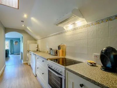 a kitchen with a stove and a counter top at Nith Riverside Cottages in Sanquhar