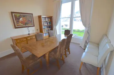 a dining room with a table and chairs and a window at Beach House - Carrick Castle in Carrick