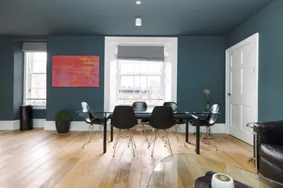 a dining room with a black table and chairs at JOIVY Spacious Apartment next to West End in Edinburgh