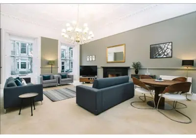 a living room with a blue couch and a table at JOIVY Elegant New Town Flat near Princes Street in Edinburgh