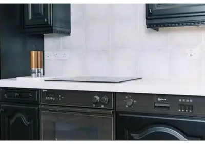a kitchen with black appliances and a white counter top at JOIVY Elegant New Town Flat near Princes Street in Edinburgh