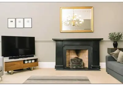 a living room with a fireplace and a flat screen tv at JOIVY Elegant New Town Flat near Princes Street in Edinburgh