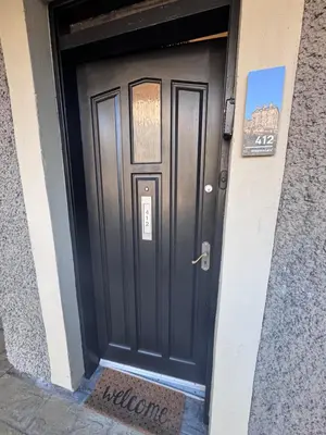 a black door to a building with a sign on it at JOIVY Stylish Castle View Flat with Balcony in Edinburgh