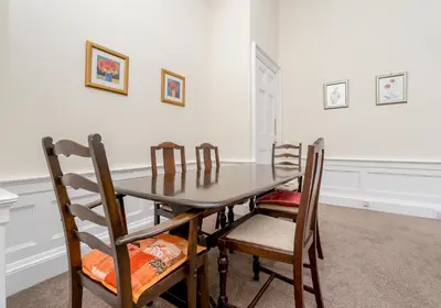 a dining room with a wooden table and chairs at Melville Street Apartment in Edinburgh