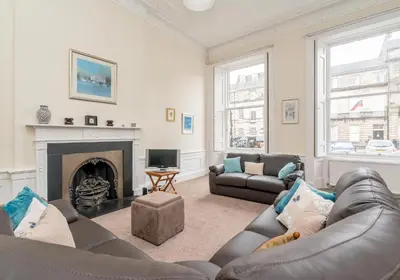 a living room with a couch and a fireplace at Melville Street Apartment in Edinburgh