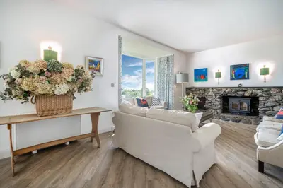 a living room with a couch and a fireplace at Crispie House in Kilfinan