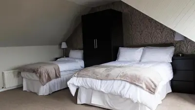 a bedroom with two beds with white sheets and a headboard at Harbourlights Accomodation in Irvine