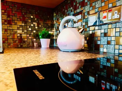 a tea kettle on a counter with a mosaic wall at Glasgow Central Station SKYLINE Apartment with Parking (2 bedrooms, 2 bathrooms, 1 living room-Kitchen) in Glasgow
