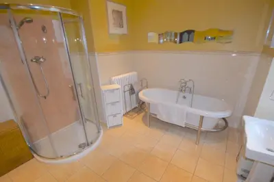a bathroom with a shower and a tub and a sink at Lettermay House in Lochgoilhead