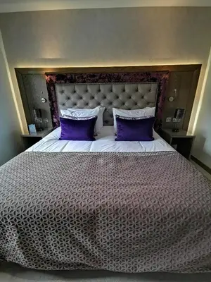 a bedroom with a large bed with purple pillows at Seamill House Hotel in Seamill