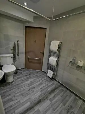 a bathroom with a toilet and a wooden door at Seamill House Hotel in Seamill