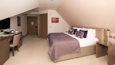 a hotel room with a bed and a desk and a sink at Seamill House Hotel in Seamill