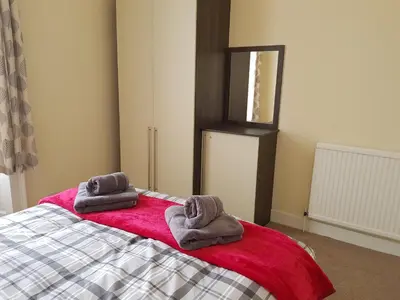 a bedroom with a bed with two towels on it at Charlotte Street 2 Bedroom Apartment in Ayr