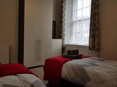 a bedroom with a bed and a window at Charlotte Street 2 Bedroom Apartment in Ayr