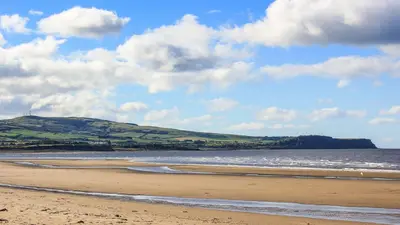 a sandy beach with a view of the ocean at Charlotte Street 2 Bedroom Apartment in Ayr